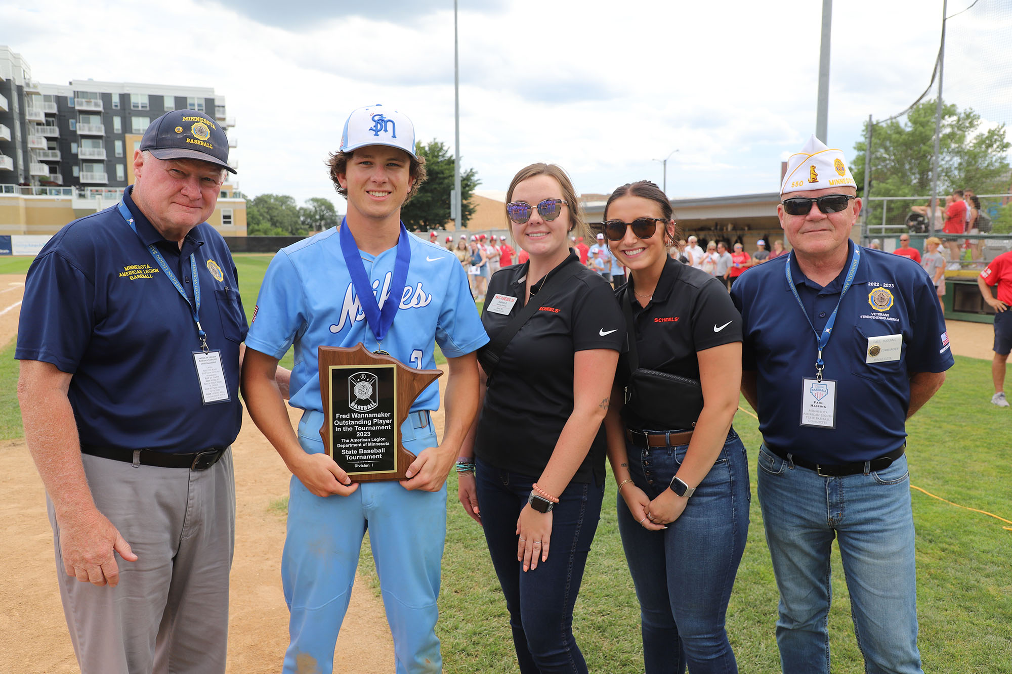 From left are Tournament Director Bruce Young, recipient Matthew Maulik of the St. Michael Mikes, Scheels represent-atives Kathryn Sands and Hailey Kiffmeyer and American Legion Department of Minnesota Commander Paul Hassing.