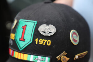 The Big Red One is the Army’s 1st Division, signified by the shoulder patch with a red one in the center. But Bill Strusinski is most proud of the combat medic badge, shown here above “1970” on his ballcap.