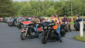American Legion Riders prepare to depart a parking lot in Pine City.